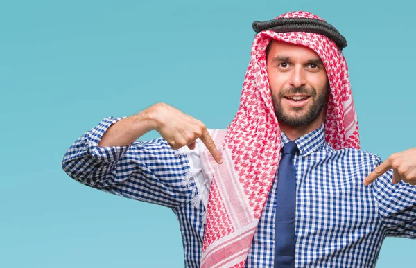 Young handsome arabian business man wearing keffiyeh over isolated background looking confident with smile on face, pointing oneself with fingers proud and happy.