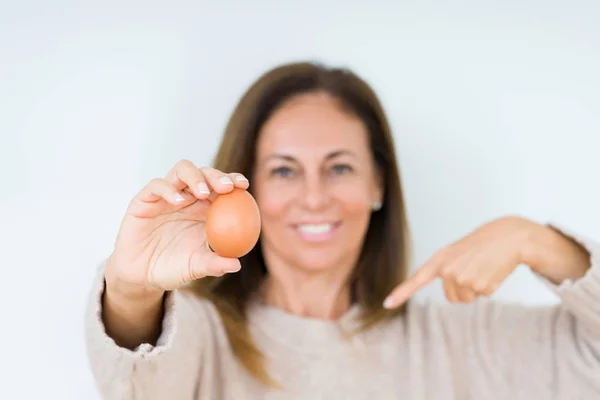 Жінка Середнього Віку Тримає Свіже Яйце Над Ізольованим Тлом Несподіваним — стокове фото