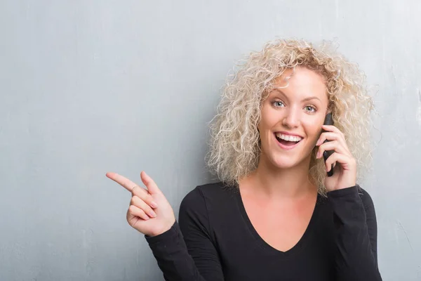 Joven Mujer Rubia Sobre Fondo Gris Grunge Hablando Por Teléfono — Foto de Stock