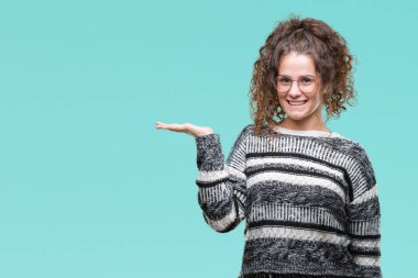 Güzel esmer kıvırcık saçlı Genç kız neşeli sunulması ve kameraya bakarak avucunun ile işaret gülümseyen izole arka plan üzerinde gözlük.