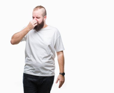 Genç beyaz hipster adam rahat t-shirt giyen bir şey pis ve iğrenç kokulu izole arka plan, dayanılmaz koku, holding nefes burun parmaklar ile. Kötü kokuyor kavramı.