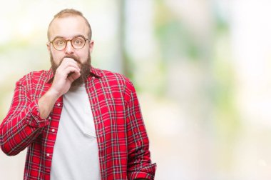 Genç beyaz hipster adam stresli ve gergin elle çivi ısırma ağzına bakarak izole arka plan üzerinde gözlük takıyorum. Anksiyete sorunu.
