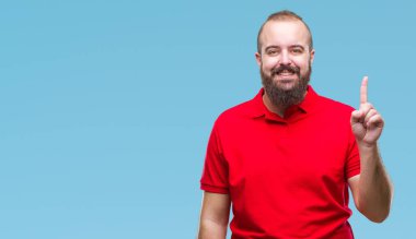 Ve parmak gülümseyen süre bir numara ile kendinden emin ve mutlu yukarıyı gösteren izole arka plan üzerinde kırmızı gömlek giymiş genç beyaz hipster adam.