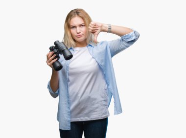 Kızgın yüz, eksi işareti aşağı antipati başparmak ile gösterilen, ret kavramı ile izole arka plan üzerinde dürbün tutan genç beyaz kadın