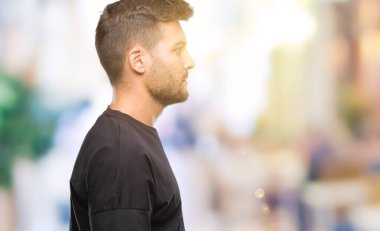 Yakışıklı delikanlı izole arka tarafına, seyir üzerinde dinlenmek doğal yüz emin gülümseme ile pozuyla profili.