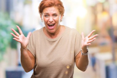 Atrractive üst düzey beyaz Kızıl saçlı kadın deli kutluyor arka plan izole ve başarı için kaldırdı kollarını açarak hayrete ve heyecanlı çığlık gözleri açık. Kazanan kavramı