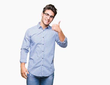 Hareketi el ile mutlu yaşasın yapıyor izole arka plan üzerinde gözlük takan yakışıklı delikanlı. Kameraya bakarak başarı gösteren ile ifade onaylama.
