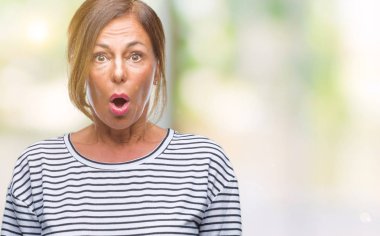 Orta yaş üst düzey İspanyol kadın izole arka plan korkuyor ve sürpriz ifade ile şok yüzünden korku ve yüz heyecanlı.