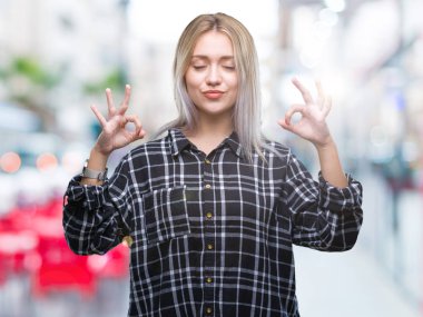 Sarışın genç kadın izole arka plan üzerinde dinlenmek ve gülümseyen gözlerle parmak ile meditasyon jest yapıyor kapalı. Yoga kavramı.