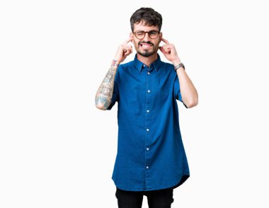 Yüksek sesle müzik gürültü rahatsız ifade parmaklarıyla kulaklarıyla kapsayan izole arka plan üzerinde gözlük takan yakışıklı delikanlı. Sağır kavramı.