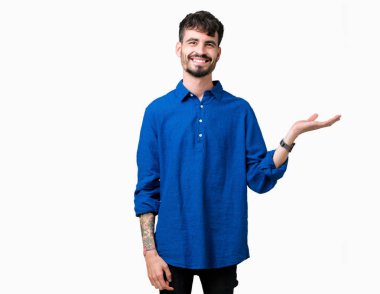 Genç yakışıklı adam neşeli sunulması ve kameraya bakarak avucunun ile işaret gülümseyen izole arka plan üzerinde.