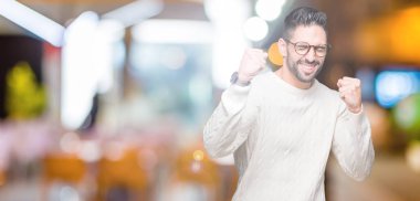 Gülümseyen ve başarı için çığlık izole arka plan çok mutlu ve heyecanlı kaldırdı, silah ile kazanan jest yapıyor üzerinde gözlük takan yakışıklı delikanlı. Kutlama kavramı.