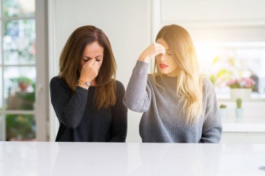 Anne ve kızı birlikte eve yorgun sürtünme burun ve gözler duygu yorgunluk ve baş ağrısı güzel aile. Stres ve hayal kırıklığı kavramı.