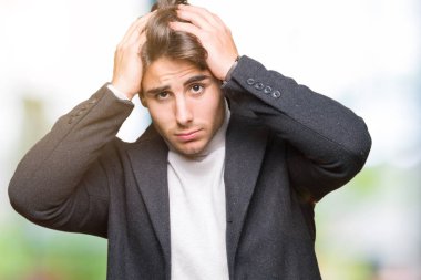 Zarif genç adam giyen kış ceket çünkü umutsuz ve stresli baş ağrısı acı izole arka plan üzerinde ağrı ve migren. Ellerini kafasına.