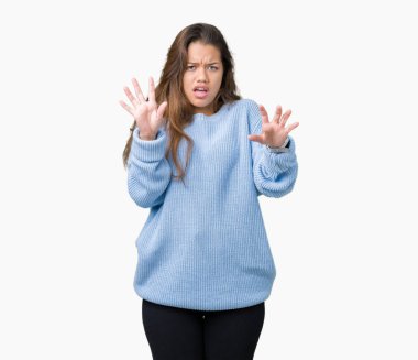 Üzerinde mavi kış kazak giyen genç güzel esmer kadın arka plan korkuyor ve korku ifade dur hareketi el ile ile dehşete şokta bağırarak izole. Panik kavramı.