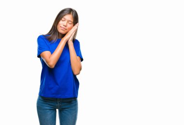 Uyku yorgun hayal ve ellerle birlikte poz ile kapalı gözler gülümseyen izole arka plan üzerinde Genç Asyalı kadın.