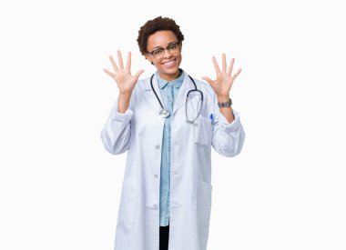 Gösterilen ve parmakları ile işaret izole arka plan üzerinde tıbbi ceket giyen genç Afro-Amerikan doktor kadın kendinden emin ve mutlu gülümseyerek süre on numara.