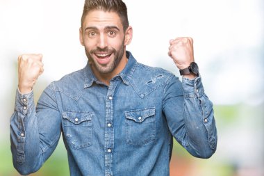 İzole arka plan kutlama üzerinde genç yakışıklı adam şaşırttı ve başarı için kaldırdı kollarını açarak hayret ve gözleri açık. Kazanan kavramı.