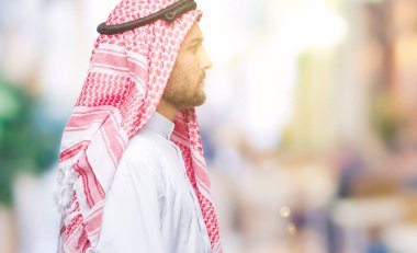 Genç yakışıklı adam giyen keffiyeh izole arka tarafına, seyir üzerinde dinlenmek doğal yüz emin gülümseme ile pozuyla profili.