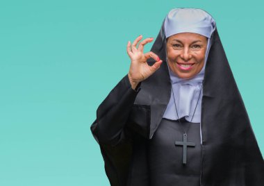 Orta yaş üst düzey Hıristiyan Katolik Rahibe kadın izole arka plan el ve parmaklar ok işaretiyle yapıyor olumlu gülümseyen üzerinde. Başarılı ifade.