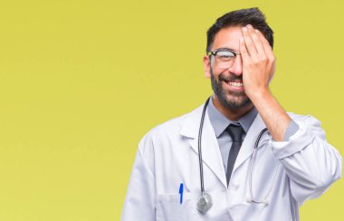 El yüz ve sürpriz duygu kendinden emin gülümseme ile tek gözüyle kapsayan izole arka plan yetişkin İspanyol doktor adam.