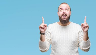 Giyen kış kazak izole arka plan üzerinden hayran ve yukarıya bakıp parmakları ile işaret şaşırttı ve silah kaldırdı Genç beyaz hipster adam.