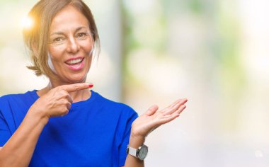 Orta yaş üzerinden hayran ve el ile sunulması ve parmak ile işaret ederken kameraya gülümseyen izole arka plan İspanyol kadın kıdemli.