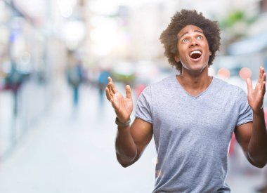 Afro Amerikalı adam izole arka plan çılgın ve kızgın bağırarak ve agresif ifade ve silah kaldırdı bağırıyor. Hayal kırıklığı kavramı.