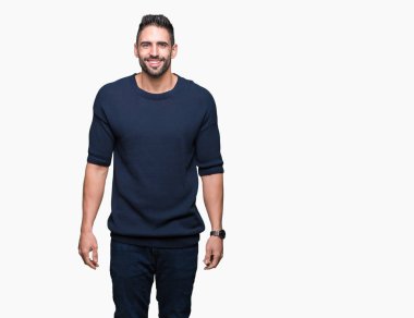 Yüzünde mutlu ve güzel bir gülümseme ile izole arka plan üzerinde kazak giyen genç yakışıklı adam. Şanslı kişi.