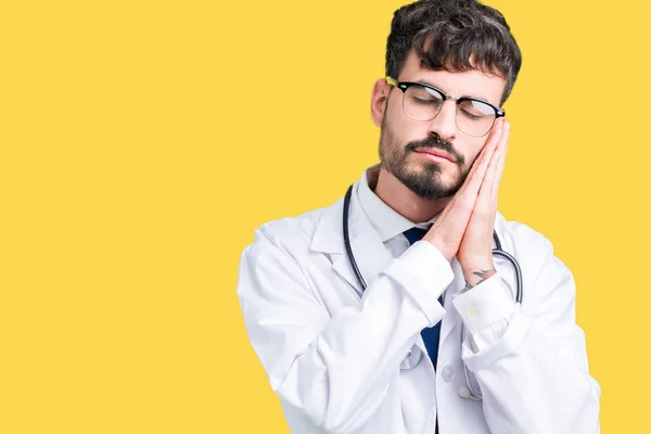 Junger Arzt Trägt Krankenhausmantel Über Isoliertem Hintergrund Schlafend Müde Träumend — Stockfoto