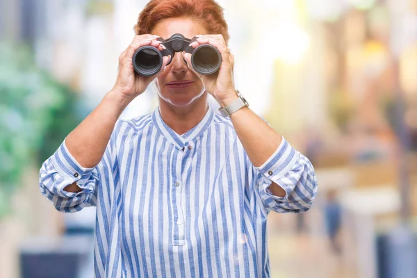 分離の背景考えて深刻なスマートの顔に自信を持って式を双眼鏡で見ている年配の白人女性 — ストック写真