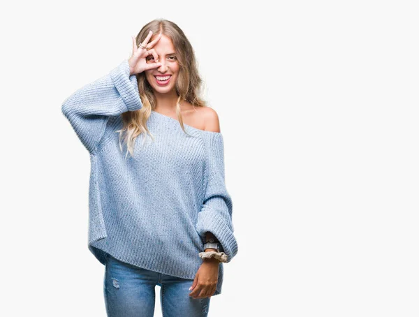 手の笑顔 幸せそうな顔で指を通して見る目で のジェスチャーを行う分離の背景に冬のセーターを着ている美しい若いブロンドの女性 — ストック写真