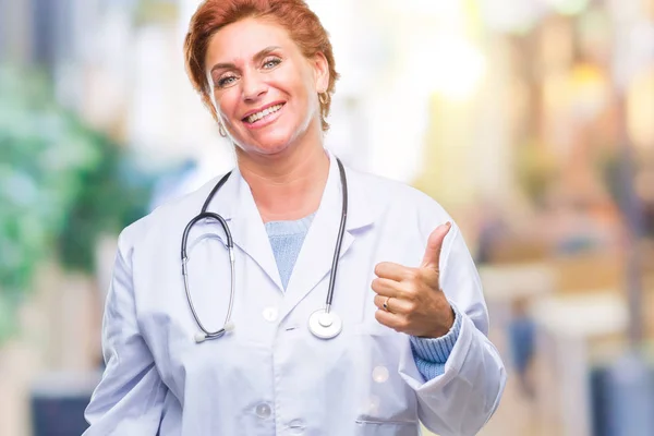 高级白种人医生妇女穿着医疗制服在孤立的背景做快乐的大拇指用手的手势 通过显示成功来批准镜头的表达 — 图库照片