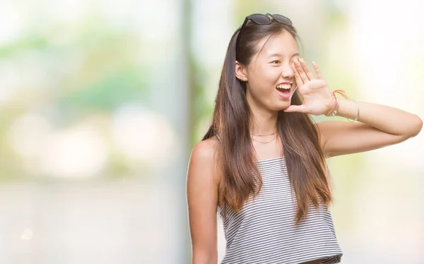 年轻的亚洲妇女戴着太阳镜在孤立的背景下大声喊叫 一边用手在嘴上尖叫 沟通理念 — 图库照片