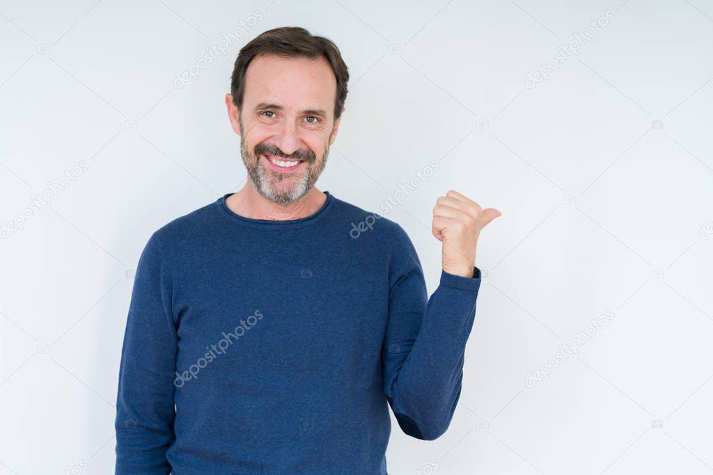 Elegant senior man over isolated background smiling with happy face looking and pointing to the side with thumb up.