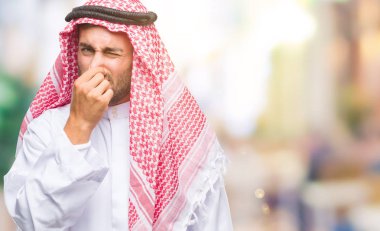 Keffiyeh bir şey pis ve iğrenç kokulu izole arka plan üzerinde dayanılmaz koku, holding nefes parmak ile burun üzerinde giyen genç yakışıklı adam. Kötü kokuyor kavramı.