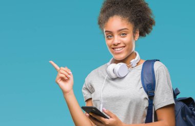 Sırt çantası izole arka plan üzerinde çok mutlu el ve parmak ile tarafına işaret tutan genç güzel afro Amerikan öğrenci kadın