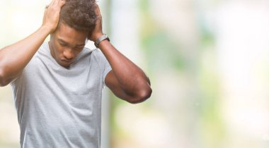 Afro Amerikalı adam çünkü umutsuz ve stresli baş ağrısı acı izole arka plan üzerinde ağrı ve migren. Ellerini kafasına.