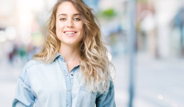 İzole arka plan ile bir mutlu ve serin güzel genç sarışın kadın yüzündeki gülümseme. Şanslı kişi.