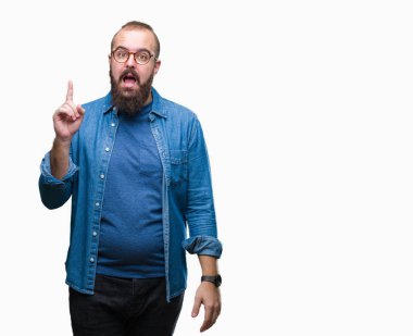 Başarılı fikirle izole arka plan işaret parmağı üzerinde gözlük takan Genç beyaz hipster adam. Çıktıktan ve mutlu. Bir numara.