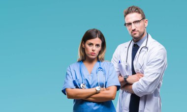 Doktor ve cerrah izole arka plan şüpheci ve sinir, onaylamayan ifade yüz çapraz kolları olan genç bir çift. Negatif kişi.