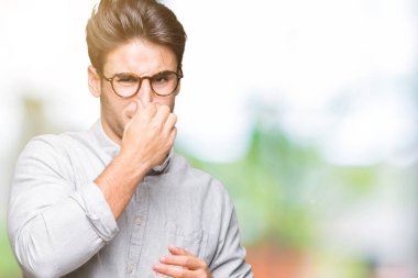 Gözlük takan bir şey pis ve iğrenç kokulu izole arka plan, dayanılmaz koku, holding nefes burun parmaklar ile yakışıklı delikanlı. Kötü kokuyor kavramı.