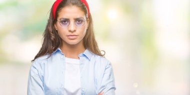 Genç güzel Arap kadın izole arka plan şüpheci ve sinir, onaylamayan ifade yüz çapraz kolları üzerinde güneş gözlüğü takıyor. Negatif kişi.