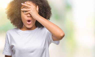 Yüz ve gözler el ile kapsayan şok bakmak izole arka plan üzerinde genç afro Amerikalı kadın mahcup ifadeyle parmaklarımın arasından arıyorsunuz.