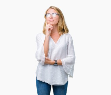 Güzel genç kadın gözlük ile izole arka plan üzerinde çene düşünme hakkında soru, dalgın ifade ver. Düşünceli yüzüyle gülümsüyor. Şüphe kavramı.