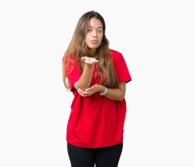 Bir öpücük el ile güzel ve seksi olmak hava üfleme kamera bakarak izole arka plan üzerinde kırmızı t-shirt giyen genç güzel esmer kadın. Aşk ifade.