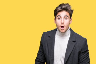 Zarif delikanlı izole arka plan korkuyor ve şok sürpriz ifade, korku ve heyecan yüz üzerinden kış palto giyiyor.