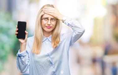 Genç Sarışın iş kadın gösteren ekran izole arka plan üzerinde Smartphone ile vurguladı güzel kafasına, utanç ve sürpriz yüz, öfkeli ve sinirli ile şok ver. Korku ve hata için üzgün.
