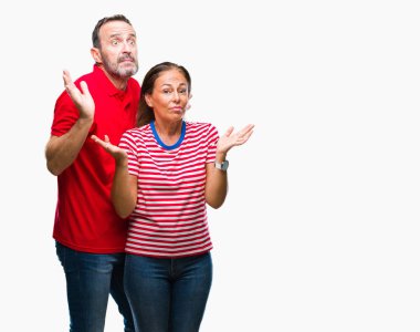 Orta yaş İspanyol kaç aşk izole içinde arka plan clueless ve şaşkın bir ifadeyle kollar ve eller kaldırdı. Şüphe kavramı.