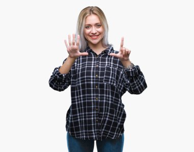 Genç Sarışın kadın gösterilen ve parmakları ile işaret izole arka plan yüzünden kendinden emin ve mutlu gülümseyerek süre yedi numara.